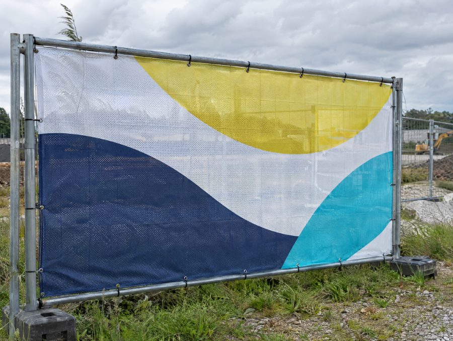 Bauzaunbanner Mesh an einem freistehenden Bauzaun